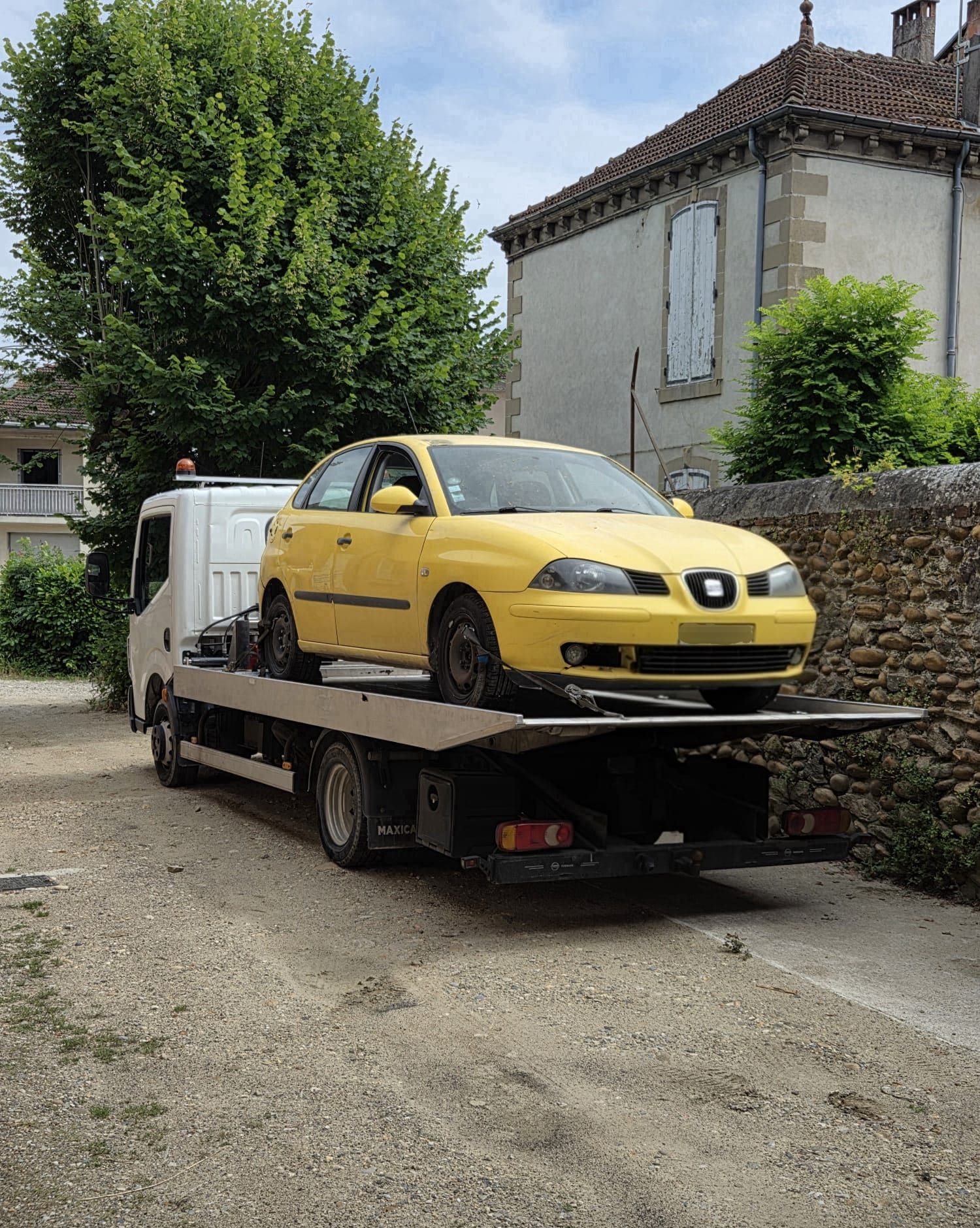 Seat Ibiza jaune hors d’usage chargée sur la dépanneuse plateau d’Épaviste Perrin