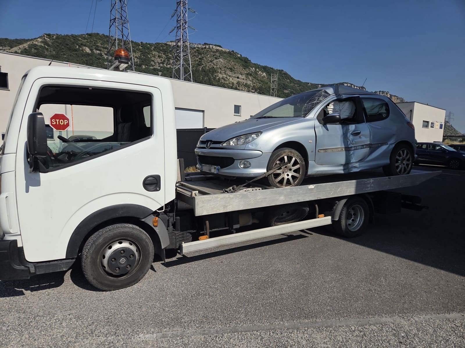 Peugeot 206 accidentée chargée sur la dépanneuse plateau d’Épaviste Perrin
