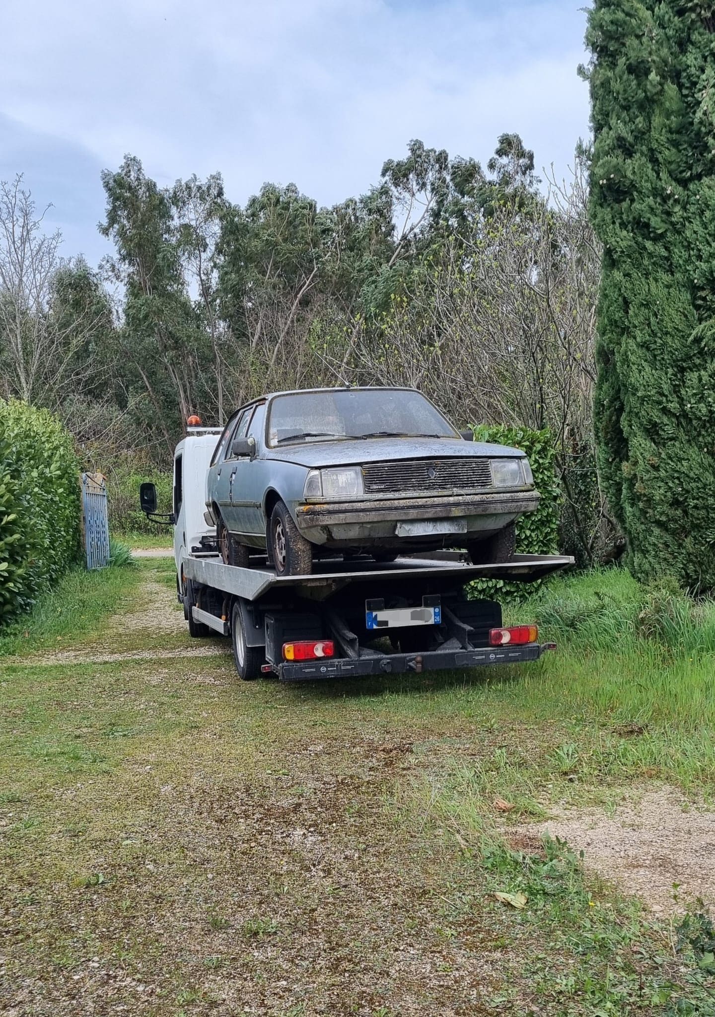 Berline ancienne hors d’usage chargée sur la dépanneuse plateau d’Épaviste Perrin